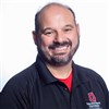 Dion Elizondo - a smiling Mexican-American man with a salt and pepper mustache and beard.  He is wearing a black Ohio State University - Office of Student Life polo with a red t-shirt underneath.