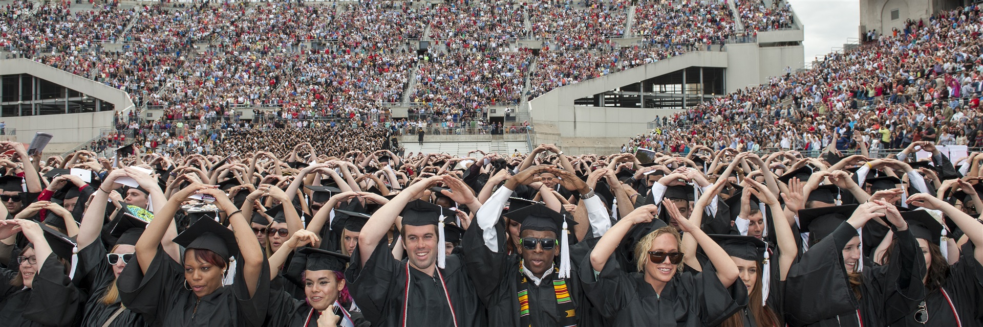 Crowd of graduating students during commencement making Block O arms.