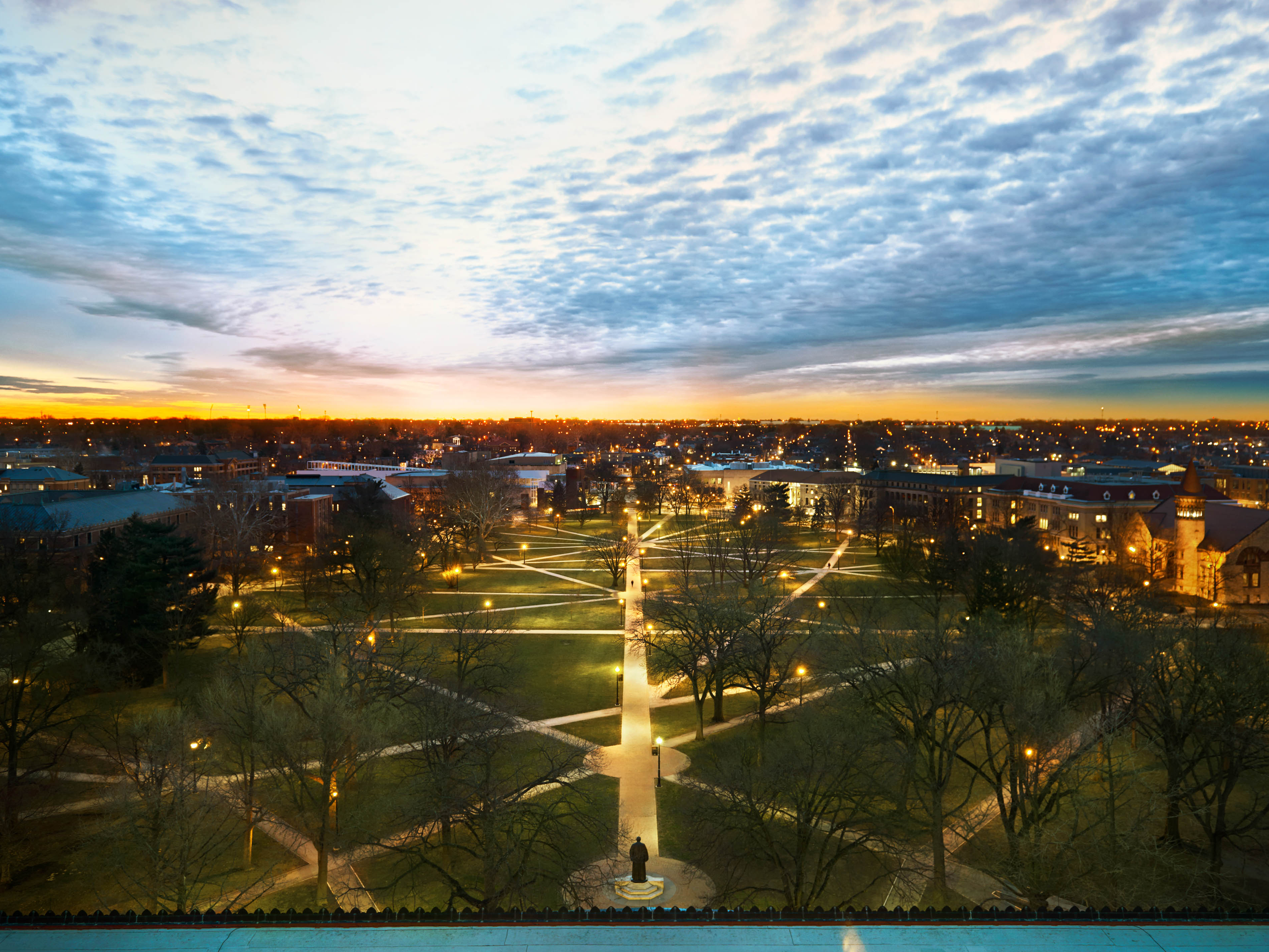 The Ohio State Oval at sunset with campus lights shining bright