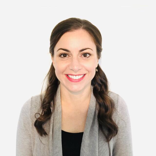 A smiling white woman with long brown hair