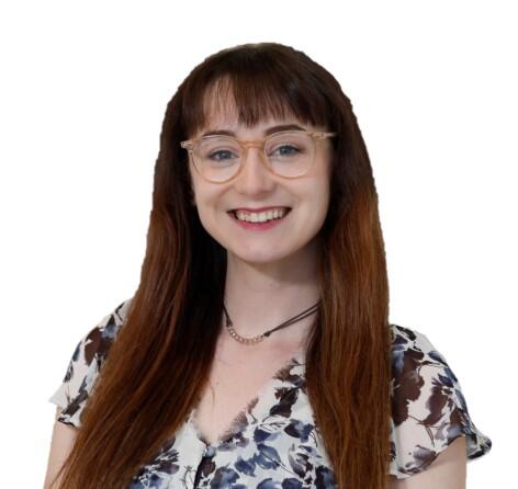 A smiling white woman a white woman with brown hair wearing a floral blouse and light brown glasses.