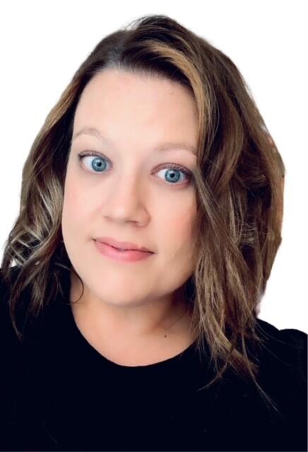 Heidi Aune (Hartley) - a smiling white woman with shoulder length brown hair wearing a black blouse.