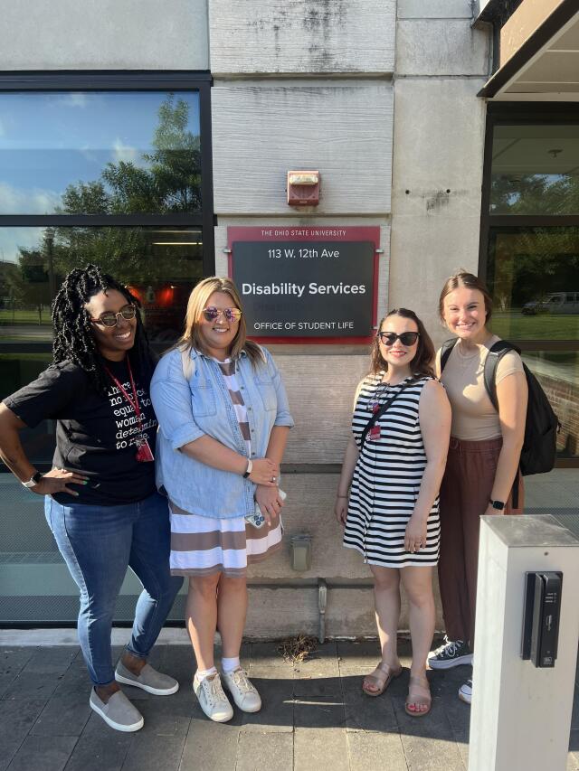 Access Specialists Jamonae, Heidi, Nathalie and Madalyn in front of the SLDS outside entrance sign.