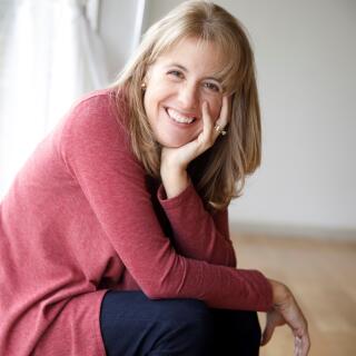 Jenny Speas- A smiling white woman with shoulder-length, brown/grey hair wearing a maroon blouse.