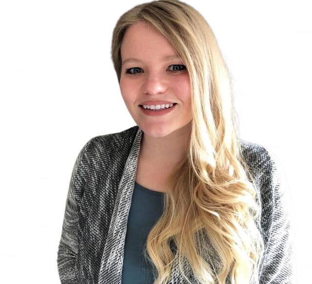 A smiling woman with blond hair wearing a cardigan over a teal blouse.