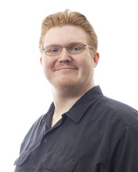 Michael Queener, a white man with short, red hair and glasses, wearing a black button-down shirt.